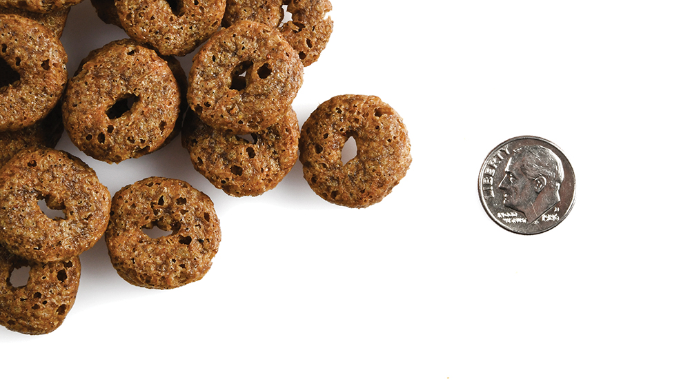 A small pile of Crunchy Os Blueberry Blasts treats next to a dime for scale