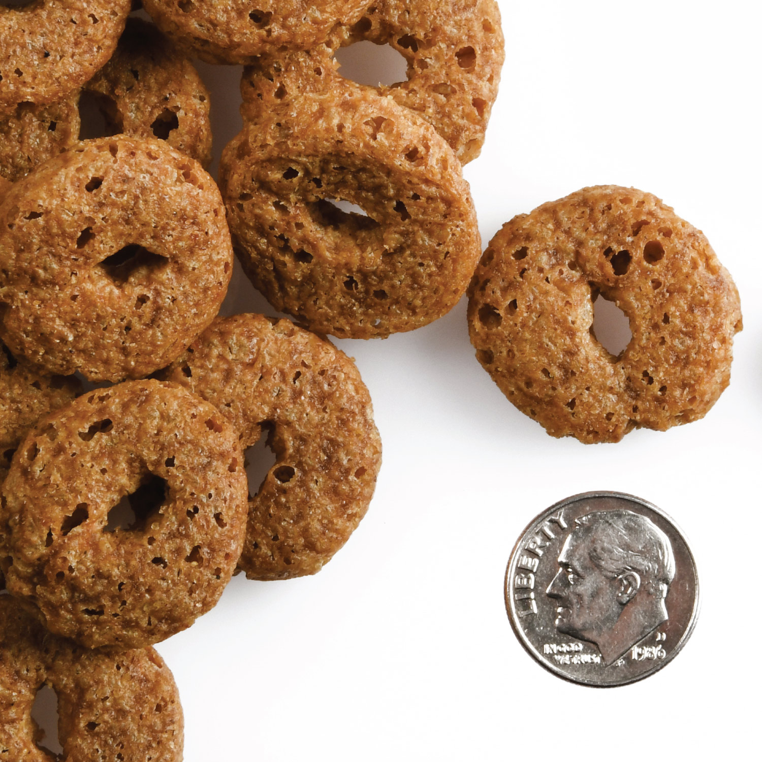 A small pile of Crunchy Os Pumpkin Cran Pow treats next to a dime for scale.