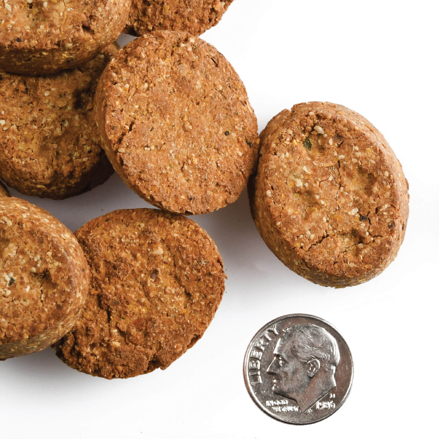 A small pile of Four-Star Chicken with Peas & Carrots treats next to a dime for scale.