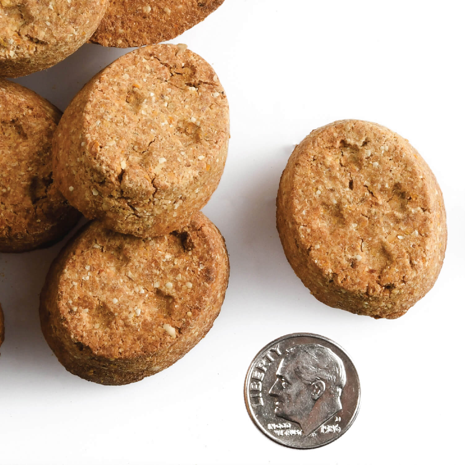 A small pile of Four-Star Lamb with Cranberry treats next to a dime for scale.