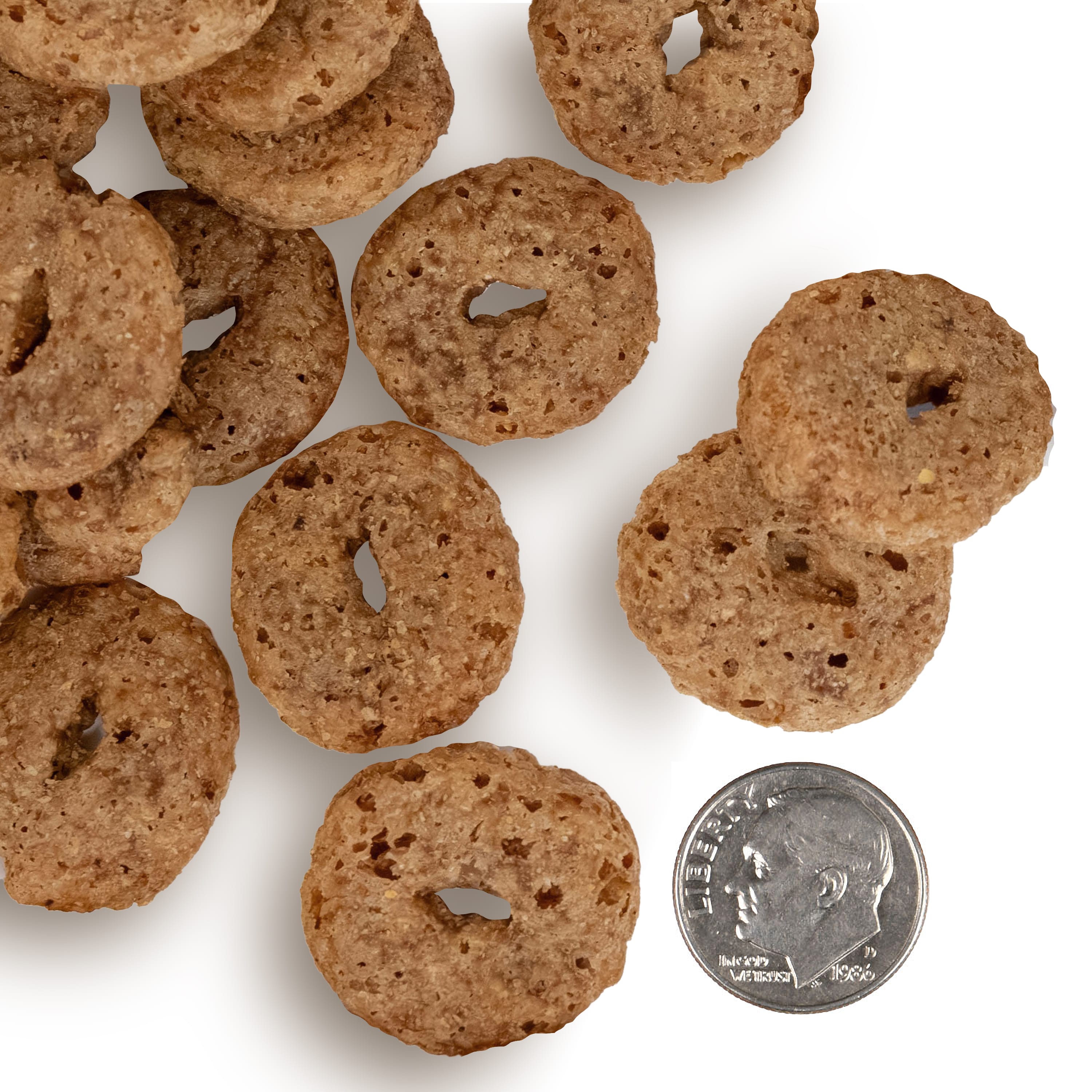 A side-by-side size comparison of Crunchy Os Bacon Blasters Dog Treats next to a U.S. dime